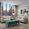 A modern living room with two cream-colored sofas, a teal ottoman, a glass coffee table, and a large abstract painting on the wall. The room is styled with beige curtains, a gray rug, and a large floor-to-ceiling window showing a city skyline at dusk.