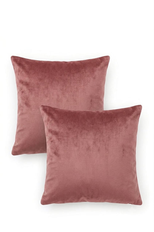 Two square velvet throw pillows in a dusty rose pink color, arranged overlapping on a clean white background.