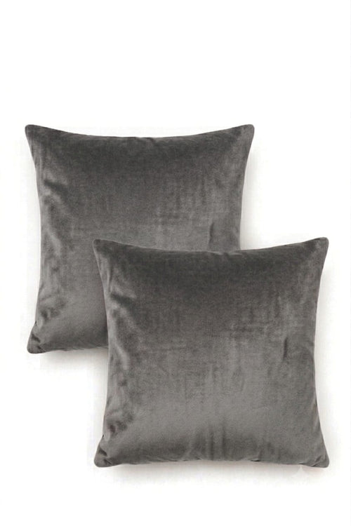 Two square dark gray velvet throw pillows arranged overlapping on a plain white background.