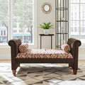 A brown upholstered chaise lounge with rolled arms and wooden legs, shown in a bright living room setting. The lounge features a patterned seat cushion in orange, beige, and brown tones, and is flanked by two matching cylindrical pillows.