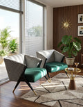 Two modern armchairs with black-and-white houndstooth upholstery and emerald green velvet seats, placed in a styled living room with wood flooring, a patterned rug, a small gold side table, and potted plants.