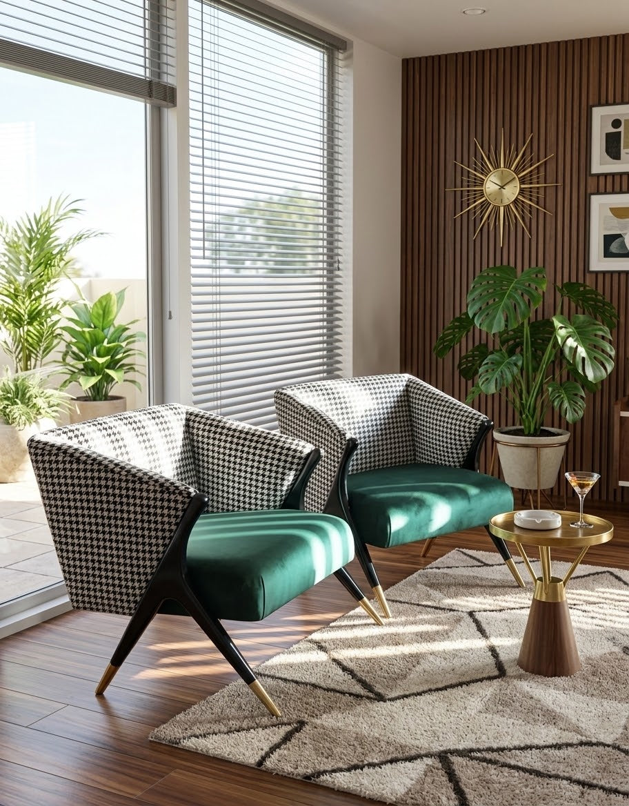 Two modern armchairs with black-and-white houndstooth upholstery and emerald green velvet seats, placed in a styled living room with wood flooring, a patterned rug, a small gold side table, and potted plants.