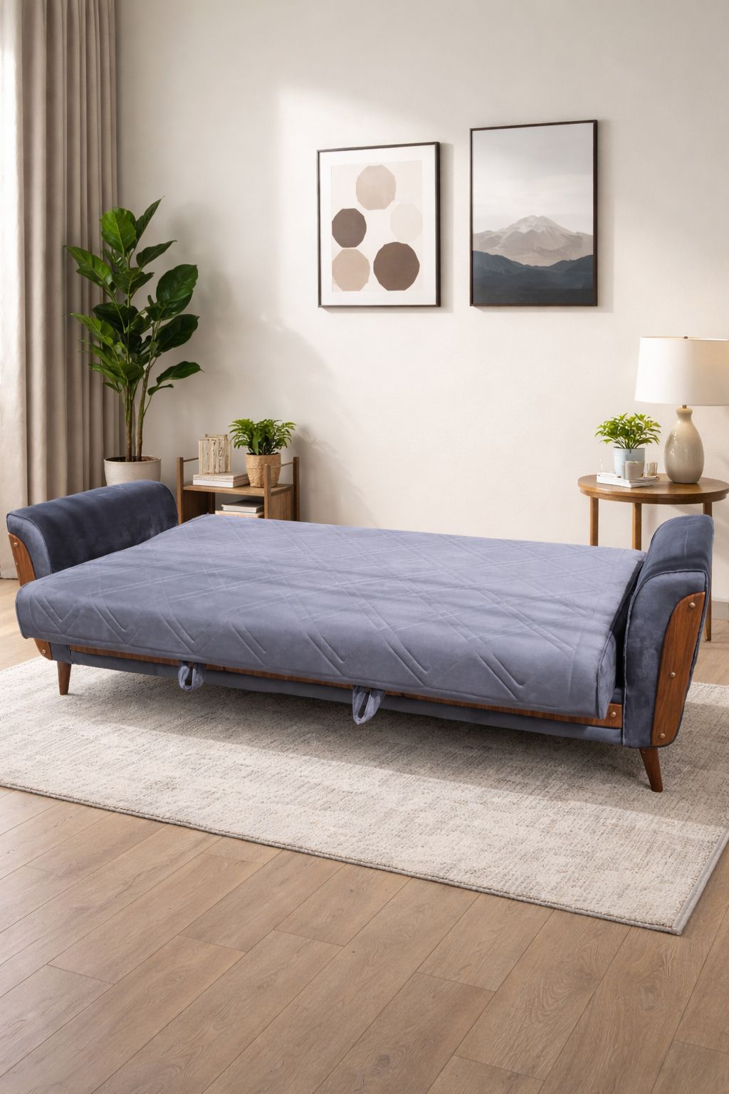 Blue sofa bed in a living room setting with decor elements.