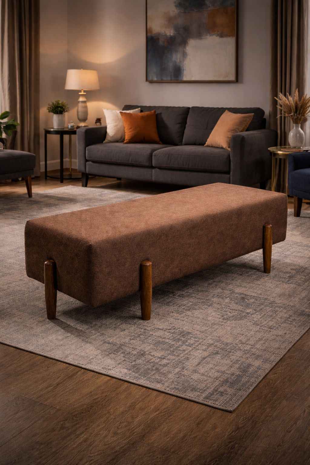 Brown ottoman in a living room setting with a gray sofa and decorative items.
